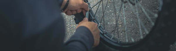 A person using a wrench on the wheel of their bike.